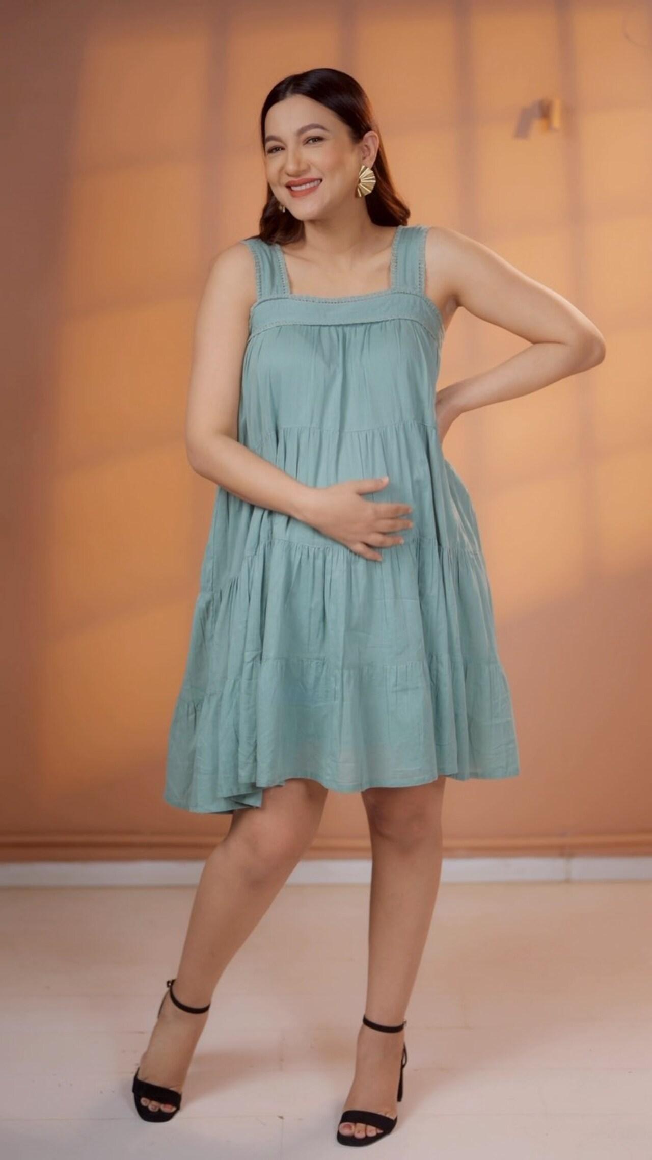 She radiates freshness in a breezy aqua-blue short dress, styled with statement earrings and black heels.